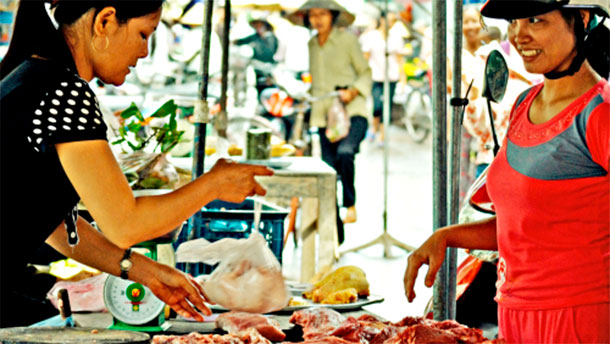 A local pork vendor at the wet market sells her meat to two local women, Hung Yen province, Vietnam (photo credit: ILRI/Nguyen Ngoc Huyen).

