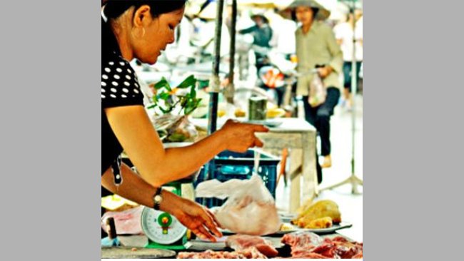 A local pork vendor at the wet market sells her meat to two local women, Hung Yen province, Vietnam (photo credit: ILRI/Nguyen Ngoc Huyen).