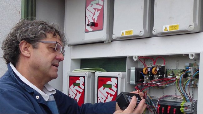 Tim Miller checks a fail-safe battery on a 400-pig place finishing building on a Midlands farm.