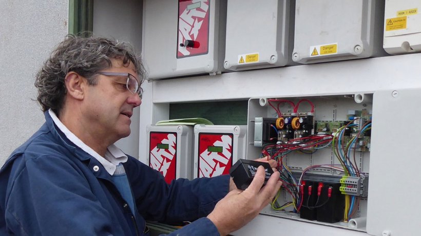 Tim Miller checks a fail-safe battery on a 400-pig place finishing building on a Midlands farm.
