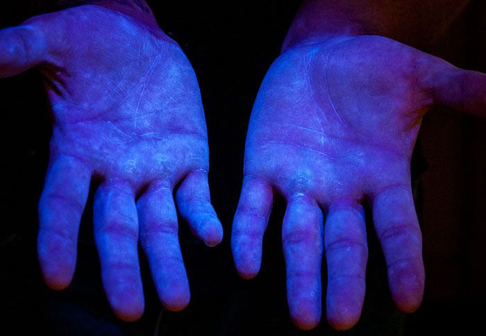Picture 6. Fluoresce material under UV light to demonstrate coverage in human hands. Source www.glogerm.com

