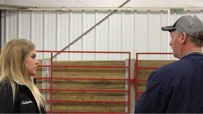 ISU student employee Michaela Friest talks with a potential buyer at the 2018 Tradition of Excellence sale hosted by ISU students at the Hansen Ag Student Learning Center.
