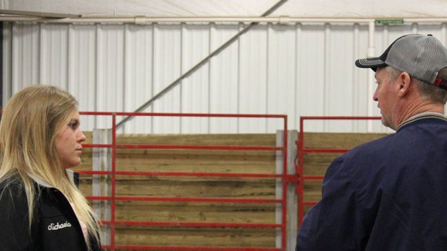 ISU student employee Michaela Friest talks with a potential buyer at the 2018 Tradition of Excellence sale hosted by ISU students at the Hansen Ag Student Learning Center.