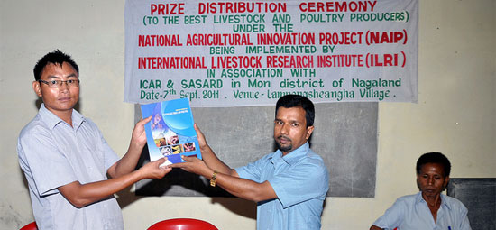ILRI scientist Ram Deka (middle) distributes training manuals to Livestock Service Providers participating in an ILRI pig production project in the state of Nagaland, in northeast India, 2011